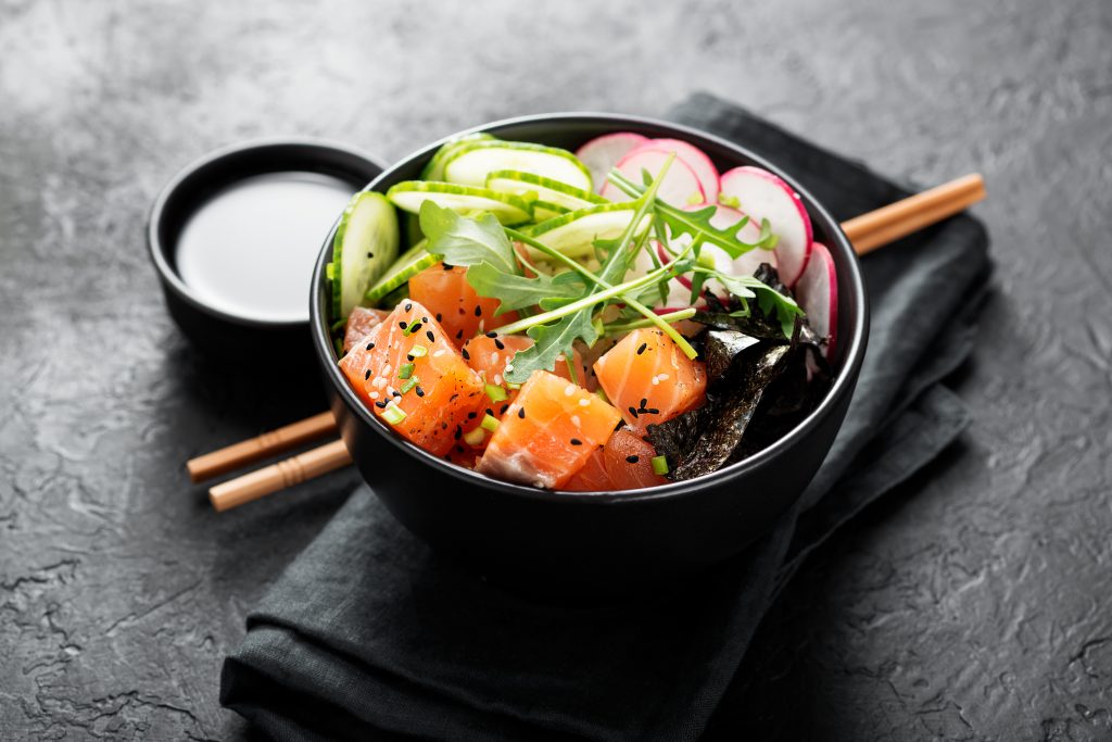 Salmon fish poke bowl with rice, radish,cucumber, tomato, sesame seeds